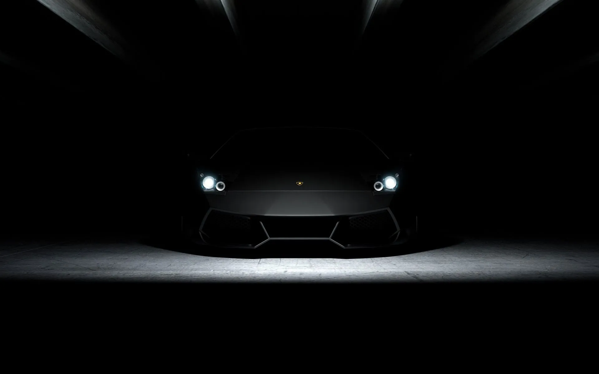 A sports car emerging from darkness with its headlights on