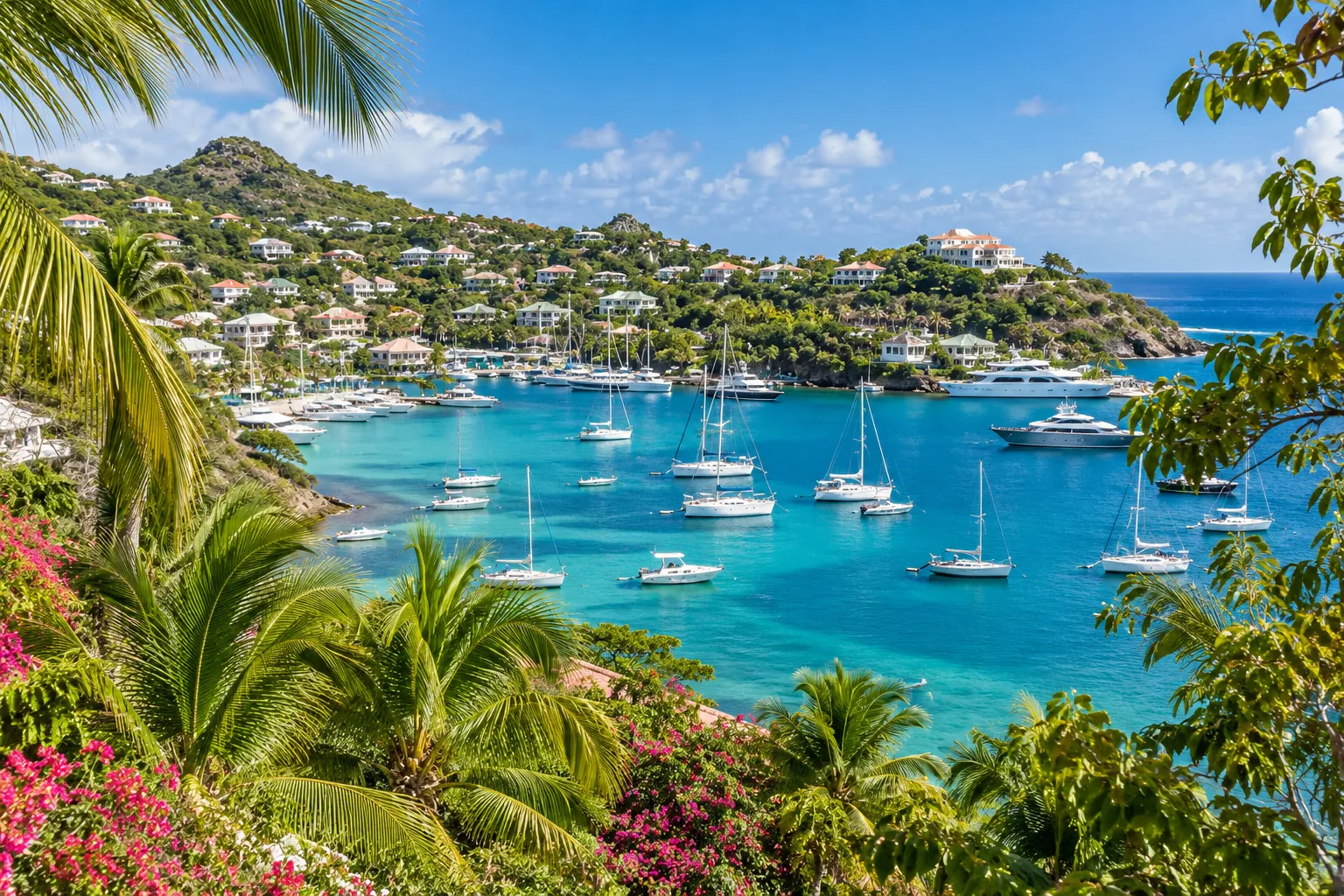 Yachts moored in a turquoise St Martin harbour below hillside villas