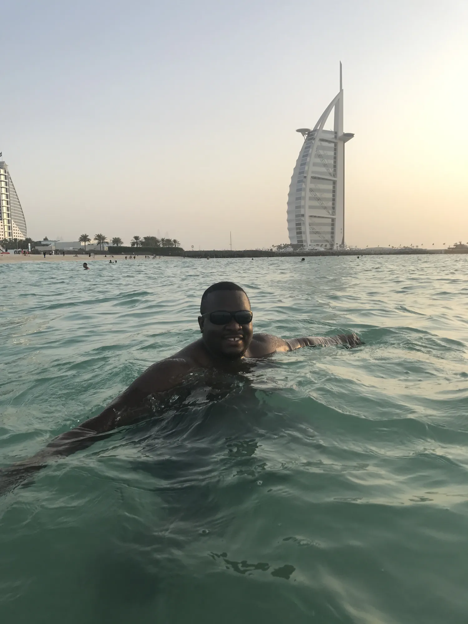 Asong swimming in the Arabian Gulf with the Burj Al Arab behind him
