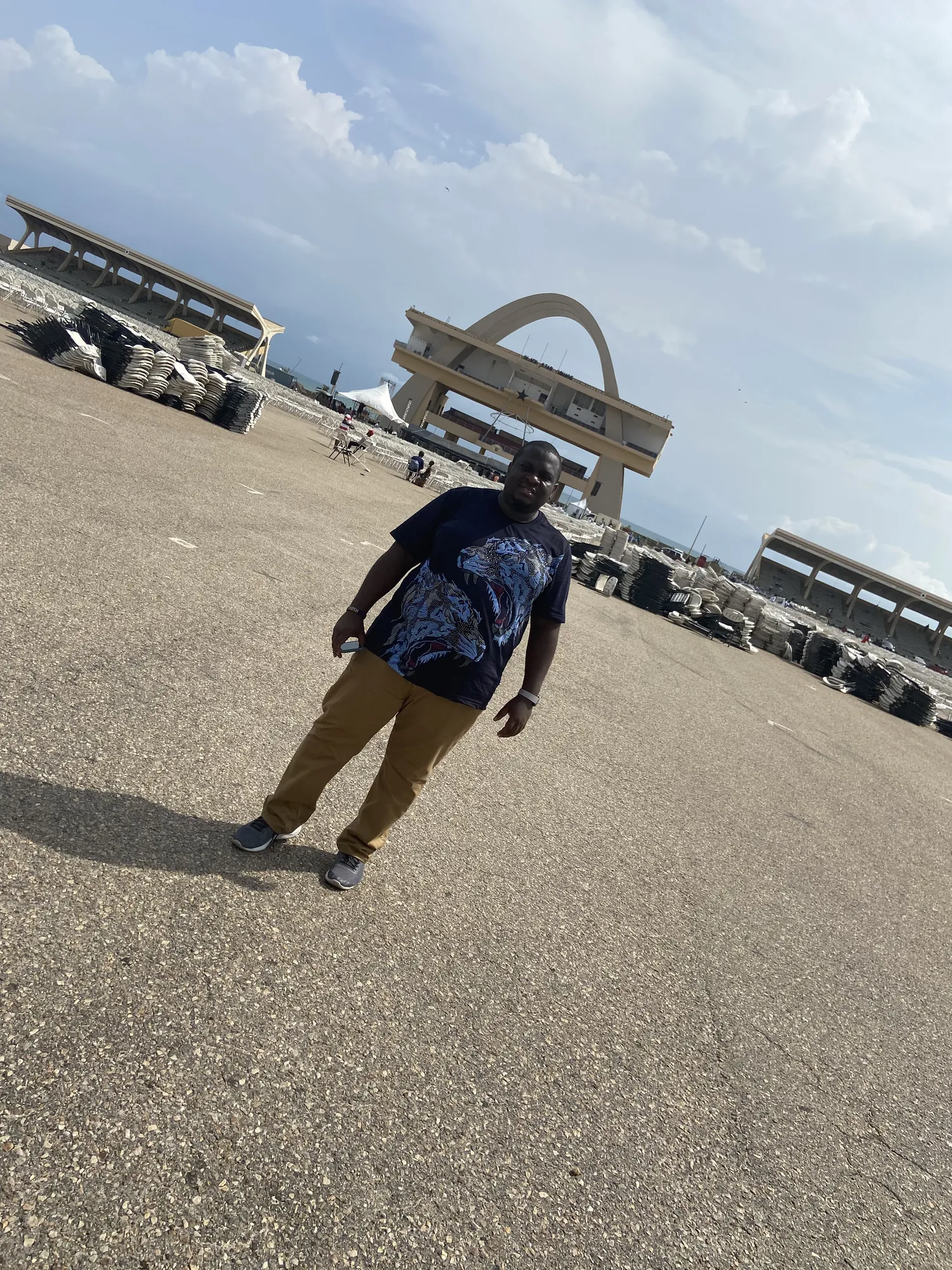 Asong crossing Black Star Square with the Independence Arch behind him