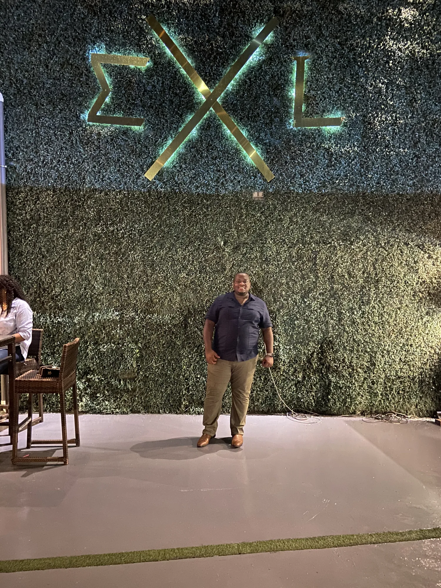 Asong in front of a living green wall at a Ghana lounge