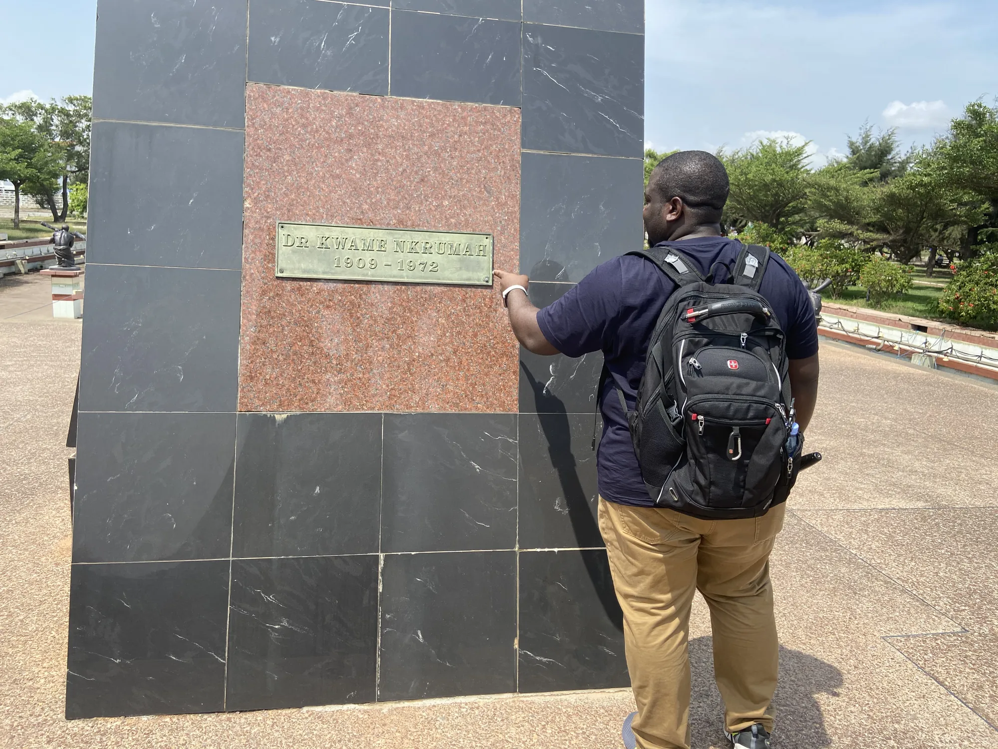 Asong reading the memorial plaque at Kwame Nkrumah Memorial Park
