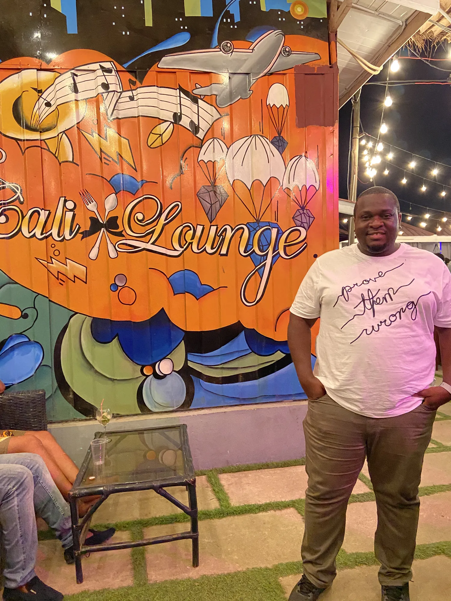 Asong beside the painted Sali Lounge mural in Ghana