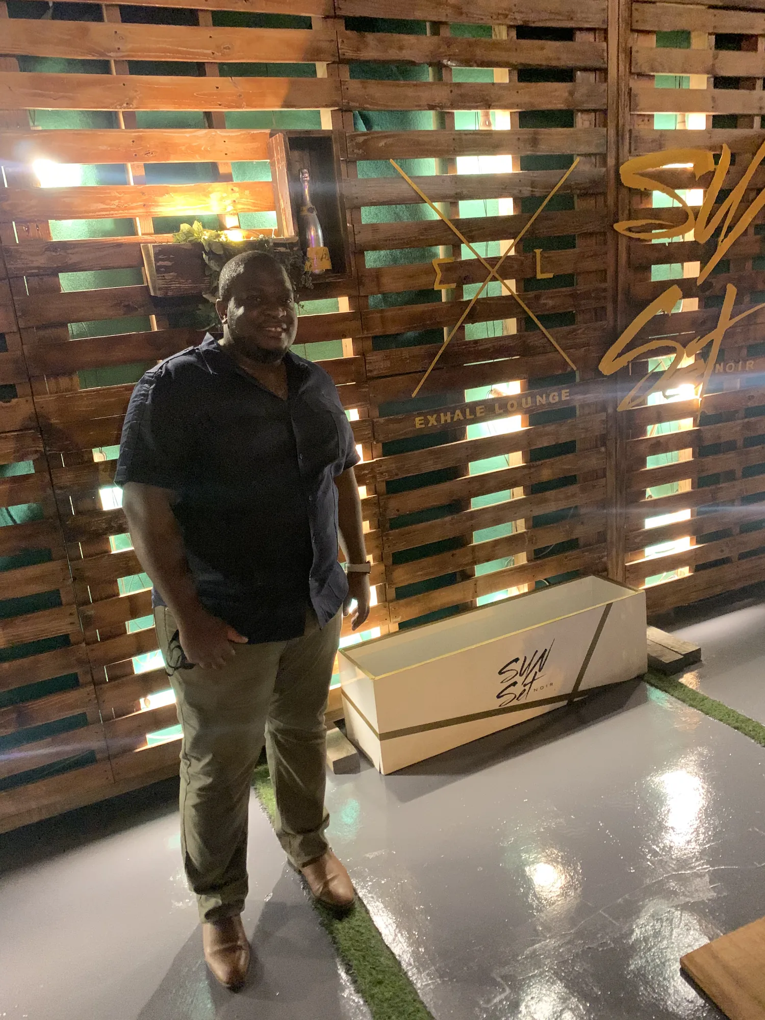 Asong standing in a warm timber-slat lounge interior