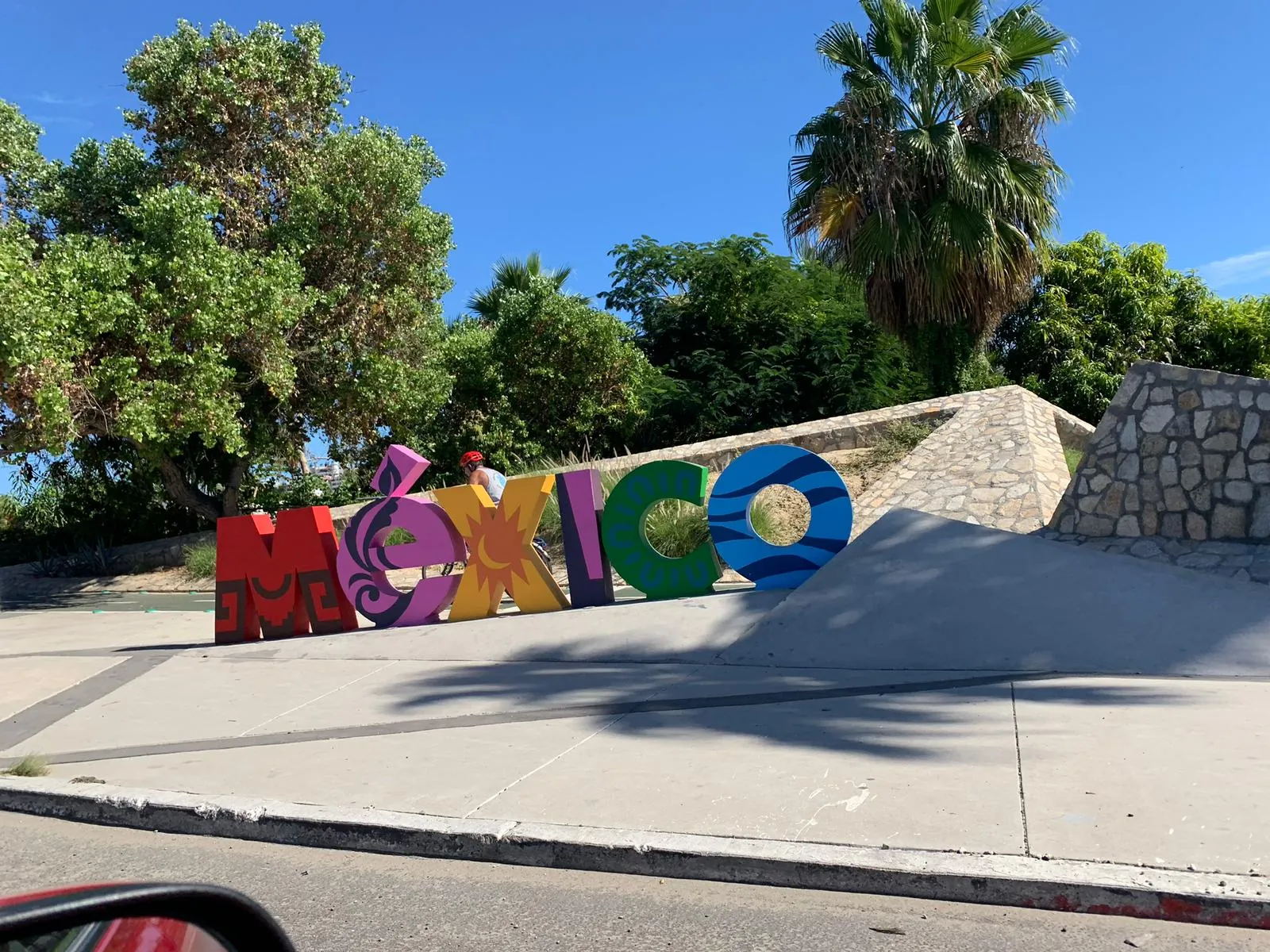 The colourful MEXICO letters by the road under palm trees