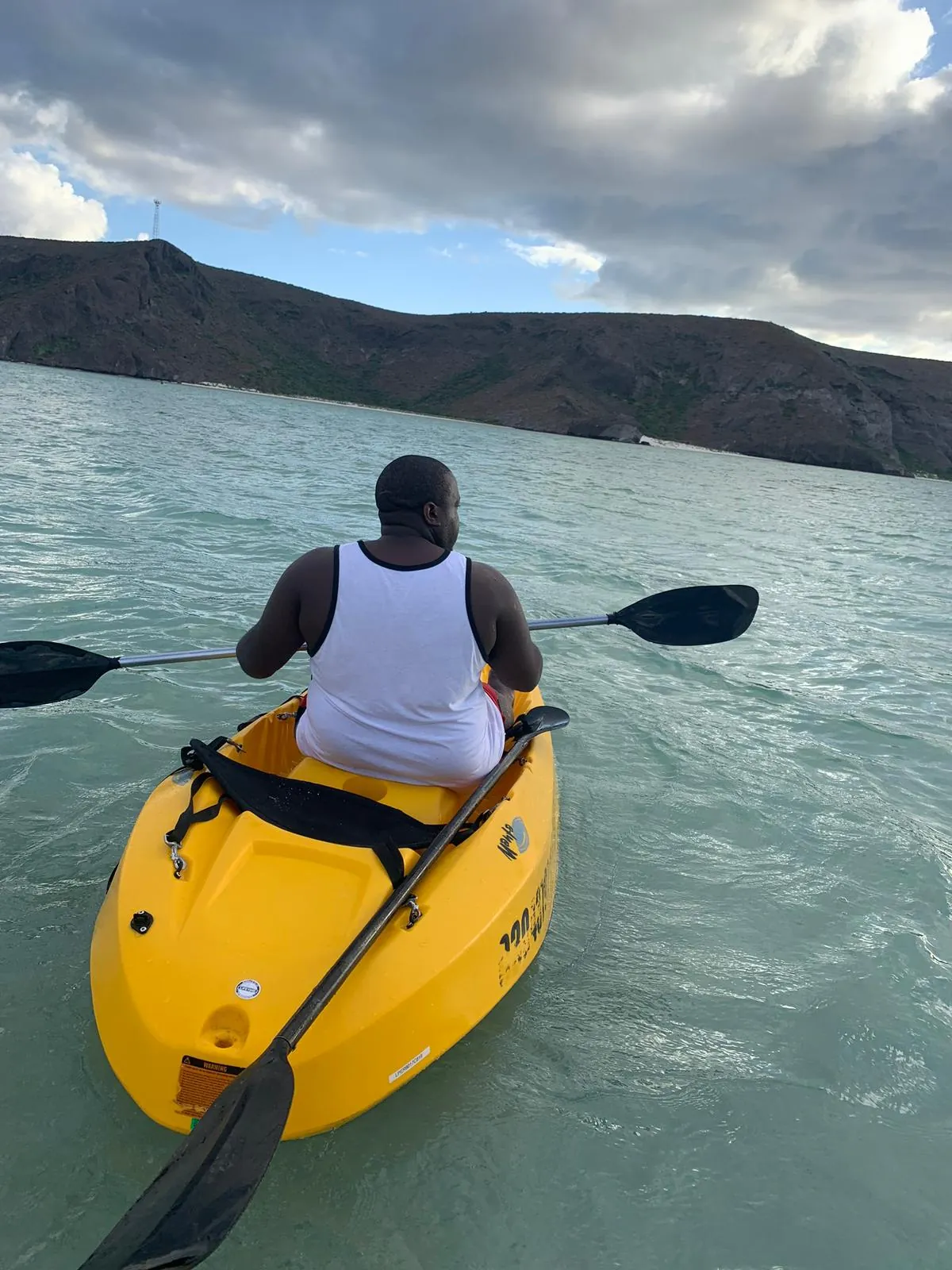 Asong paddling a yellow kayak on the Sea of Cortez