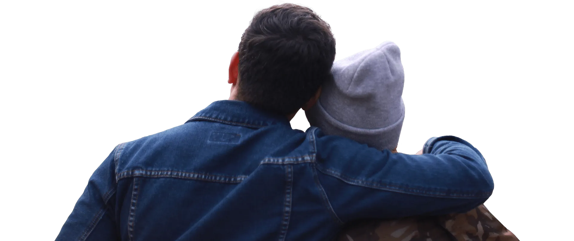Two travellers in denim jackets resting heads together, looking out